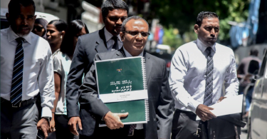 Former Attorney General Husnu Al-Suood with the copy of the "big" constitution that was presented to the Attorney General's Office. PHOTO / TWITTER