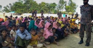 Rohingya Muslims from Myanmar, who tried to cross the Naf river into Bangladesh to escape sectarian violence, are kept under watch by Bangladeshi security officials in Teknaf on December 25, 2016. Border Guard Bangladesh (BGB) personnel have intercepted 34 boats carrying some 340 Rohingyas at border points near Cox's Bazar. / AFP PHOTO / STR