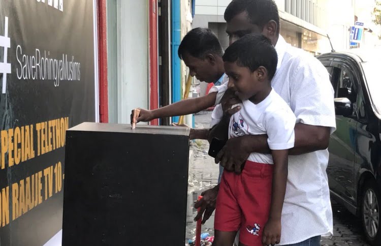 A boy puts money in a fund box placed by Raajje TV to raise aid for the persecuted Rohingya Muslims of Myanmar. PHOTO/TWITTER