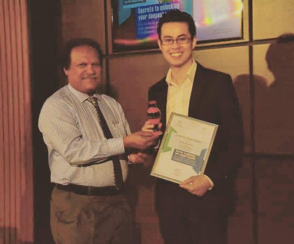 Dr. Tan Kwan Hong receiving an award from the President of the Civil Service Commission in Maldives.