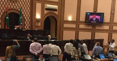 Speaker Abdulla Maseeh addresses the first sitting of 2017's third term of the parliament from his elevated seat behind a wooden "wall", while opposition lawmakers protest and call on him to step down. PHOTO/MAJLIS