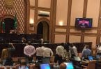 Speaker Abdulla Maseeh addresses the first sitting of 2017's third term of the parliament from his elevated seat behind a wooden "wall", while opposition lawmakers protest and call on him to step down.