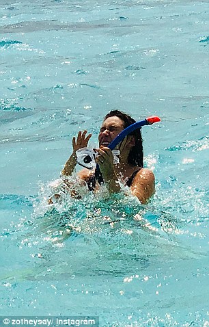 Awkward! In the photos, Zoe can be seen struggling to untangle the mask from her hair, while appearing to have water in her eyes