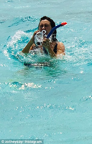 Awkward! In the photos, Zoe can be seen struggling to untangle the mask from her hair, while appearing to have water in her eyes