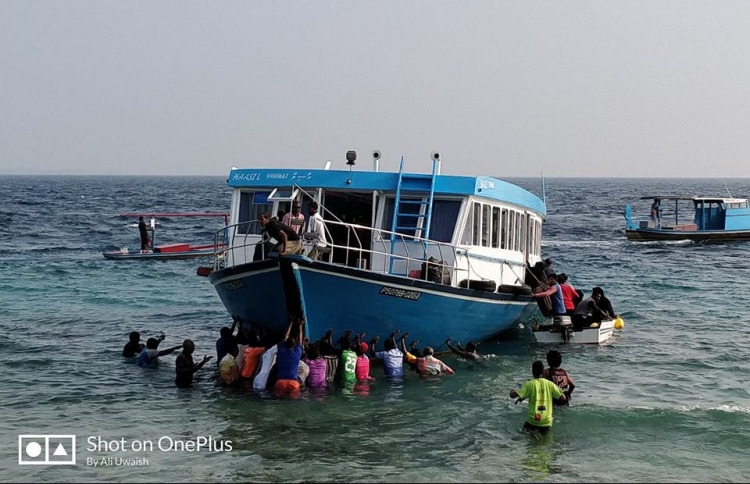 The residents of H. Dh. Kurimbi bringing ashore the boat that ran aground a reef early on January 09, 2018. The boat was en route to H. Dh. Kulhudhufishi when the incident occurred. PHOTO / ALI UWAISH