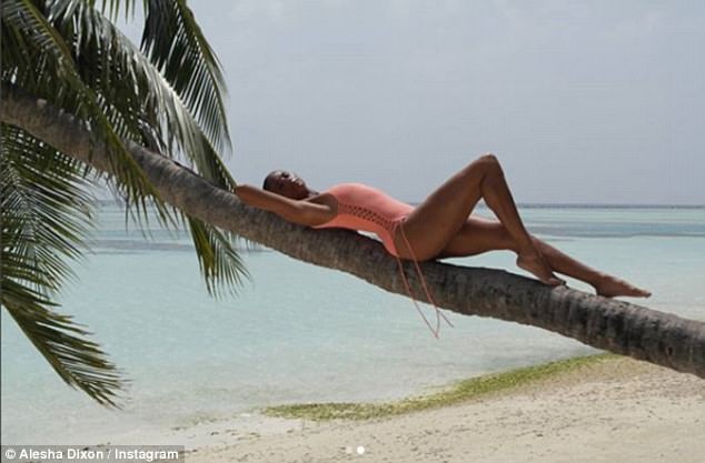 Stunning: Her radiant complexion glowed as she donned a complementary coral swimsuit, embellished with cut out features